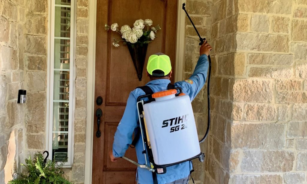 Greengate technician completing a perimeter pest control service in Missouri City TX