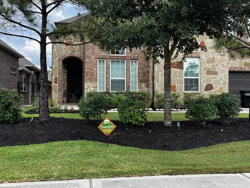 GreenGate Turf & Pest Yard Sign near a flower bed after a lawn pest control treatment was completed
