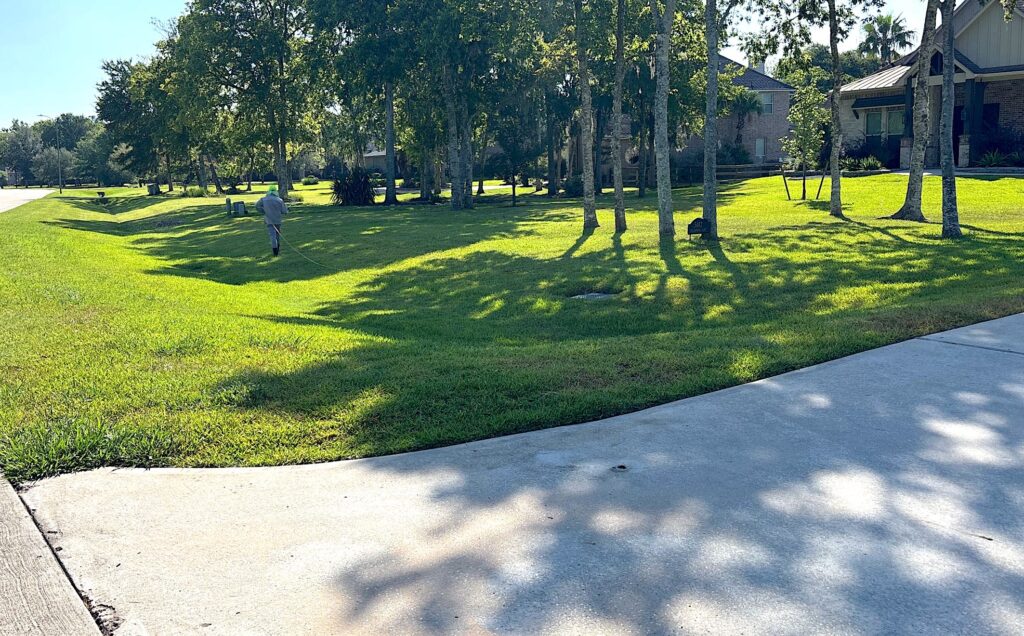 Technician treating a property with lawn fertilizer service and weed control