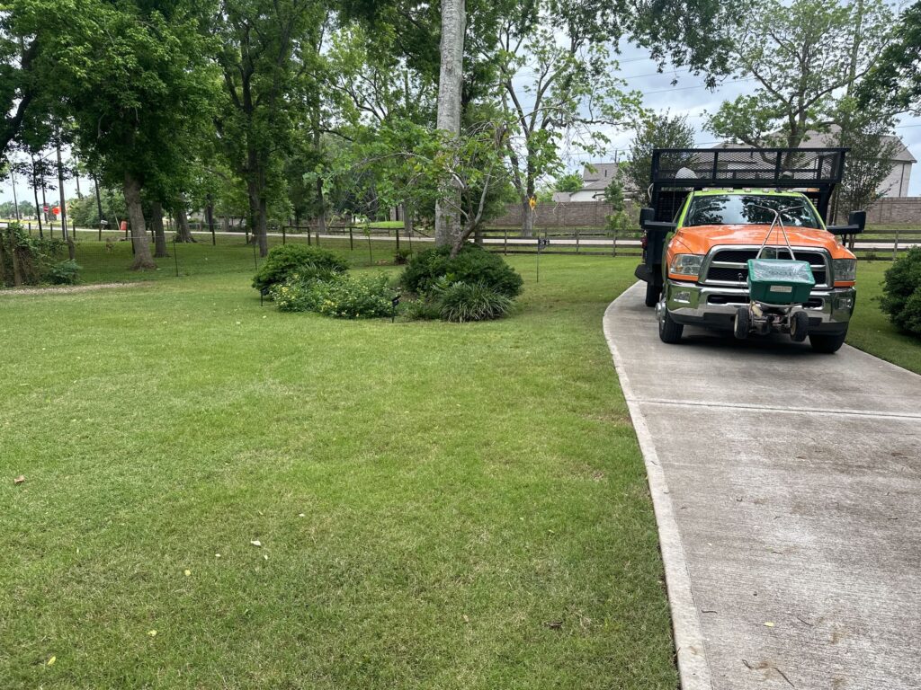 Green lawn with a GreenGate truck in drive way after applying a fertilization treatment and weed control