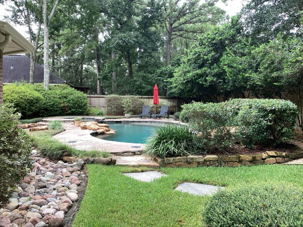 Backyard with a pool and lush landscaping with In2care Mosquito traps placed discretely