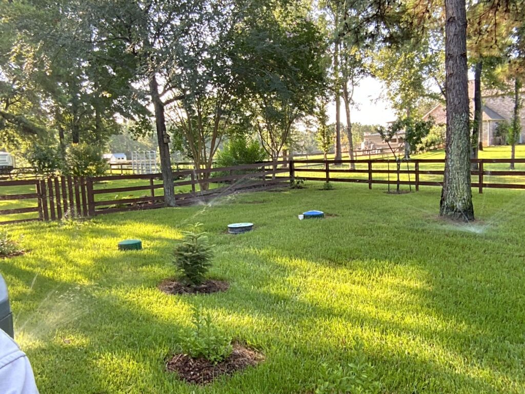 Lawn Sprinklers running in a fenced-in yard